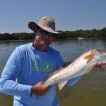 fisherman holding a fresh caught redfish out of Clearwater Florida