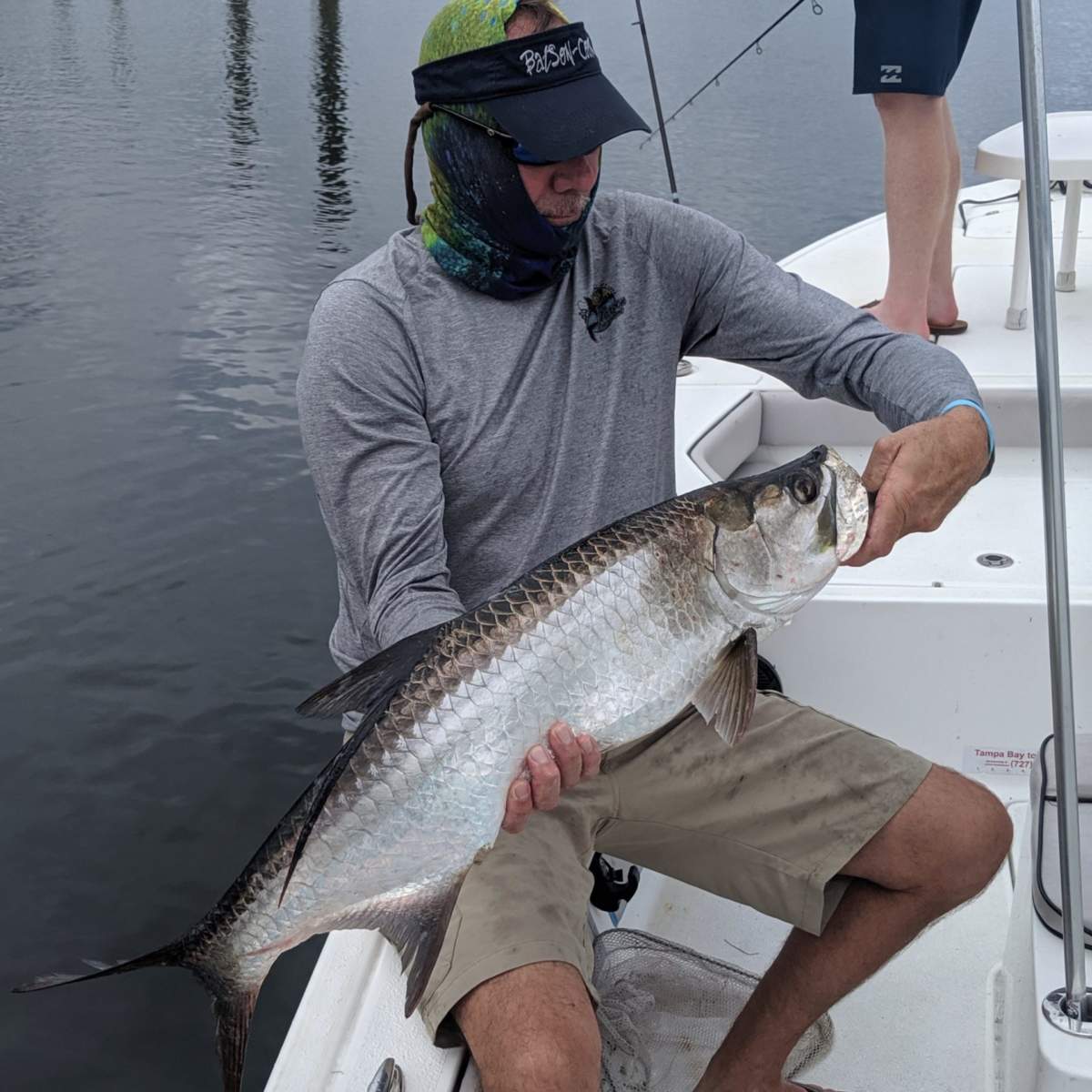 Fisherman with small tarpon caught in Tampa Bay
