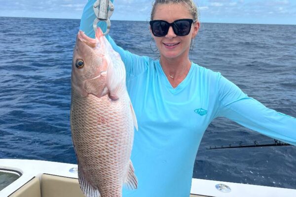 Client holding up an offshore mangrove snapper caught offshore of Tampa Bay with fishnfl